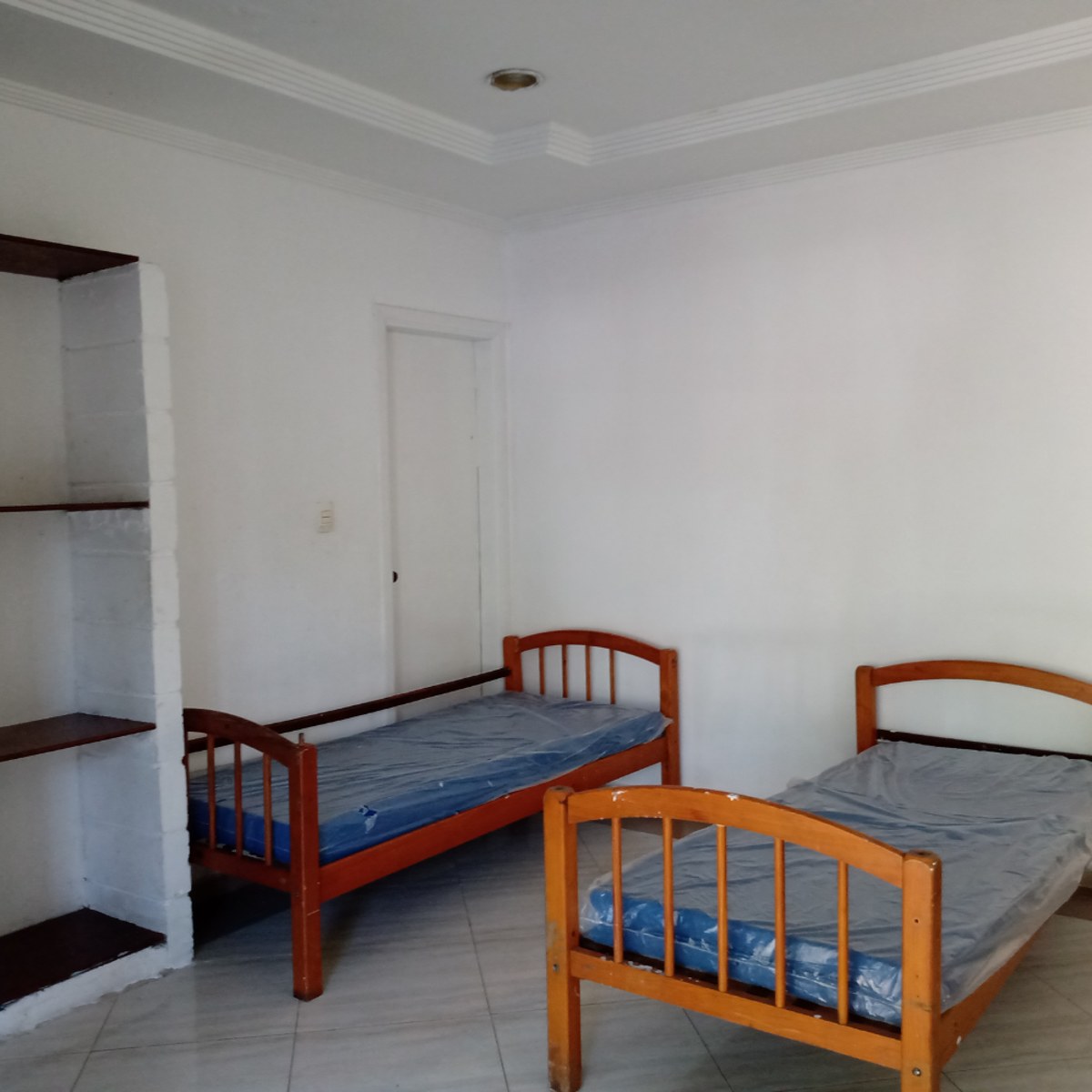 Quarto simples com duas camas na unidade de Itanhaém.